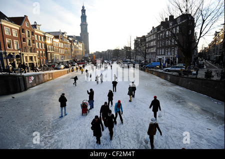 Die Menschen gehen auf zugefrorenen Kanälen im Zentrum von Amsterdam, Niederlande. Stockfoto