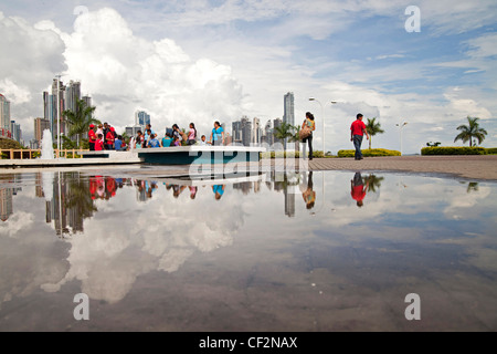 Skyline und Passanten in einer Pfütze auf der renovierten Strandpromenade von Cinta Costera reflektiert und die von Panama-Stadt Stockfoto
