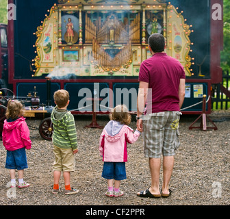 Vater und Kinder betrachten eine Dampf-Orgel der Audley End Steam Gala 2011. Stockfoto