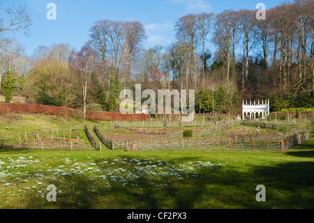 Painswick Rokoko-Garten an einem sonnigen Wintertag mit der Exedra und Banken von Schneeglöckchen, im Vordergrund.  VEREINIGTES KÖNIGREICH. Stockfoto