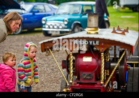 Eine Mutter und ihre Kinder eine Miniatur angetriebenen Dampftraktor an Audley End Steam Gala 2011 betrachten. Stockfoto