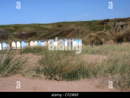 Strandhütten auf einem zerklüfteten Strand mit Dünen im Vordergrund Stockfoto