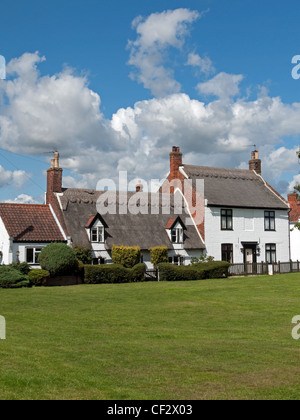 Strohgedeckten Hütten on The Green in der historischen Dorf Martham in Norfolk, England Stockfoto