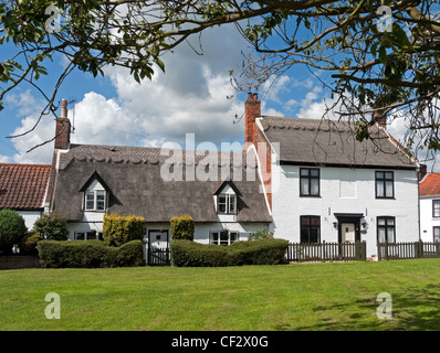 Strohgedeckten Hütten on The Green in der historischen Dorf Martham in Norfolk, England Stockfoto