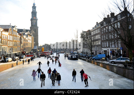 Die Menschen gehen auf zugefrorenen Kanälen im Zentrum von Amsterdam, Niederlande. Stockfoto