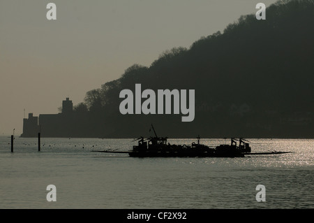 Die unteren Ferry überquert den Fluss Dart zwischen Kingswear und Dartmouth in South Devon, Dartmouth Schloß im Hintergrund. Stockfoto