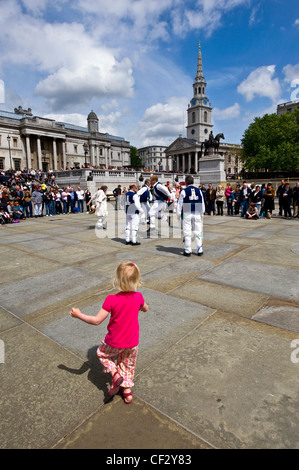 Ein junges Kind schließt sich mit dem Whitchurch Morris Männer tanzen an der Westminster Day of Dance am Trafalgar Square. Stockfoto