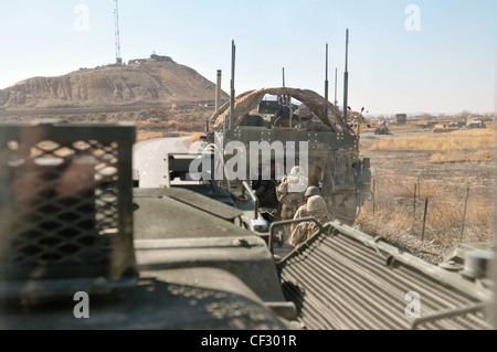 US Army COL. Todd Wood, Kommandant des 1. Stryker Brigade Combat Team, 25th Infantry Division, tritt nach Abschluss einer Fußpatrouille in einen Stryker ein, um das Gebiet in der Nähe von COP Sperwan Ghar im Panjwa’i Bezirk, Kandahar Provinz, Afghanistan am 27. Februar 2012 zu beurteilen. Stockfoto