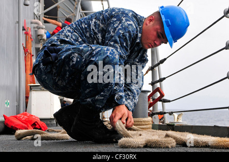 GOLF VON GUINEA (FEB 28, 2012) – Seamannlehrling Ethan Elks von der Fregatte USS Simpson mit geführten Raketen (FFG 56) legt während der Übung Obangame Express Festungslinien an. Obangame Express ist eine maritime Übung auf See, die die Zusammenarbeit zwischen den teilnehmenden Nationen verbessern soll, um die Sicherheit und Sicherheit im Seeverkehr im Golf von Guinea zu erhöhen. Stockfoto