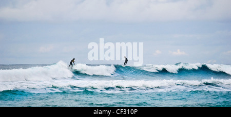 Surfer auf den Wellen Sennen Cove. Stockfoto