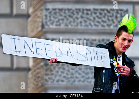 Ein Punk hält ein Schild, das liest, "Ich brauche einen Joint". Stockfoto