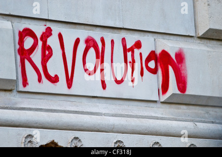 "Revolution" in roter Sprühfarbe auf eine Wand geschrieben. Stockfoto