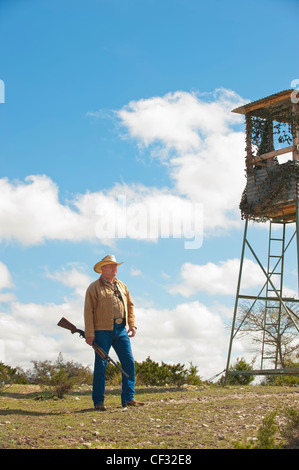 Amerikanischer Mann mit Waffe stehen neben Jagd stand Stockfoto