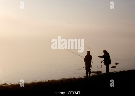 Die Silhouetten von zwei Angler, die im Bassenthwaite Lake im Lake District. Stockfoto