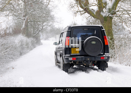 Land Rover Discovery getrieben entlang Schnee bedeckten Feldweg (verdeckt Nummer Platte & Händler Name entfernt) Stockfoto