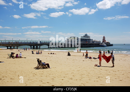 Menschen entspannen am Sandstrand neben Bournemouth Pier. Stockfoto