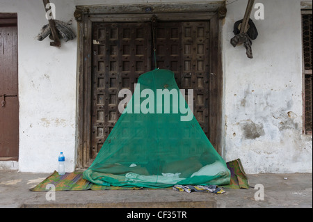 Mann draußen schlafen unter einem Moskitonetz Stone Town Sansibar Tansania Stockfoto