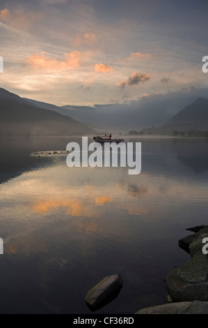 Sonnenaufgang über den reflektierenden ruhigen Gewässern des Sees Padarn in Llanberis. Stockfoto