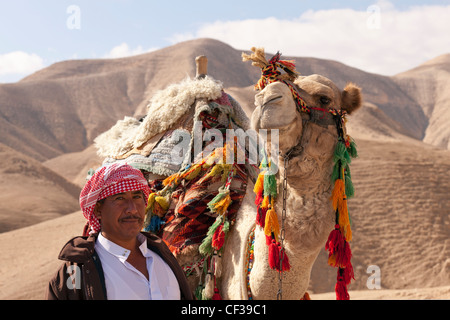 Israel, Judäische Wüste, Beduinen und Kamel inmitten der Wüste Stockfoto