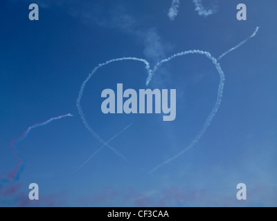 Ein Herz machte der Rauch hängt in einem blauen Himmel über Guernsey nach einem roten Pfeile angezeigt. Stockfoto