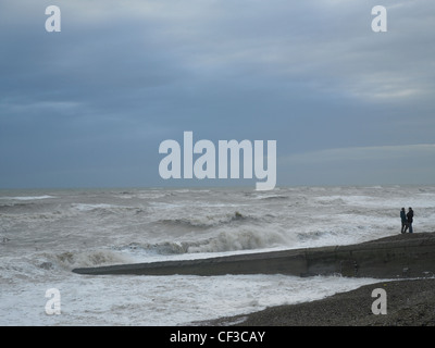 Stürmischer See unter grauem Himmel mit Wellen, die an der Küste von Brighton. Stockfoto