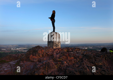 Eine Frau stand am Anfang von Arthurs Seat, die Aussicht über die Stadt Edinburgh genießen. Stockfoto