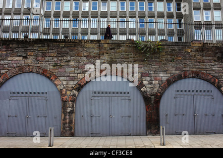 Eine Frau zu Fuß entlang East Market Street über Sperren Ups in den Bögen unten. Stockfoto