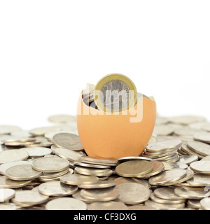 Zerbrochene Eierschale auf Münzen Stockfoto