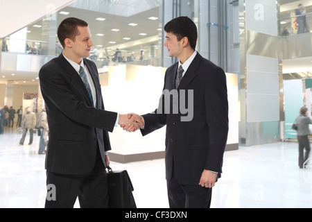Zwei junge Unternehmer begrüßen im Business Center collage Stockfoto