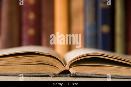 Ein offenes Buch und Bücher in einem Regal an der Cambridge University Library. Die Bibliothek enthält mehr als 7 Millionen Bücher und Zeitraum Stockfoto