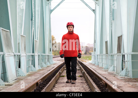 Mann-Arbeiter blind in einen Helm steht auf der Schiene Brücke Stockfoto