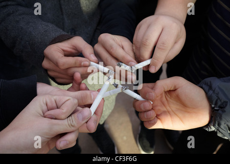 sechs Hände von Jugendlichen mit Zigaretten Stockfoto