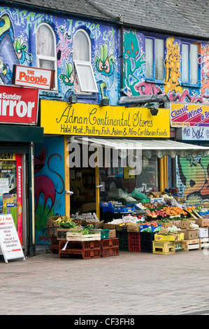 Bunte Graffiti über eine Reihe von Muli-ethnischen Geschäften in Cowley Road in Oxford. Stockfoto