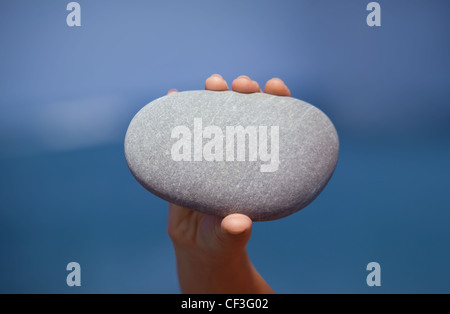 weibliche Hand, die Kiesel gegen Meer, Hintergrund für text Stockfoto