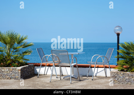 Ruhen Sie auf Küste. Tisch und Stühle am Strand klar Sommertag. Stockfoto