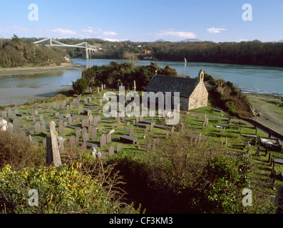 St. Tysilio Kirche und Friedhof Kirche Insel in der Meerenge von Menai mit Telford die Menai Hängebrücke in der Ferne. Stockfoto