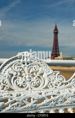 Reich verzierte Sitzplätze auf zentralen Pier mit Blackpool Tower im Hintergrund. Stockfoto