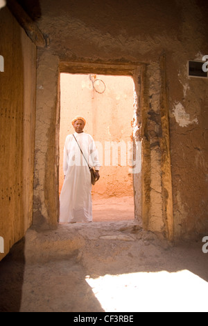 Ein marokkanische Mann in traditioneller Kleidung steht in der Tür ein marokkanisches Haus. Stockfoto
