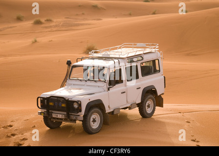 Ein off-Road 4 x 4 Fahrzeug steht in den Dünen der Wüste in der Nähe von Merzouga Erg Chebi. Stockfoto