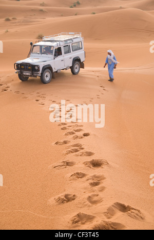 Eine marokkanische Fahrer stand neben seinem Jeep Tour in der Wüste Marokkos. Stockfoto