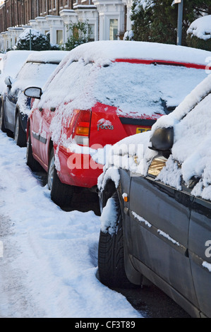 Eine Reihe von Schnee bedeckt entlang einer Straße in York geparkten Autos. Stockfoto