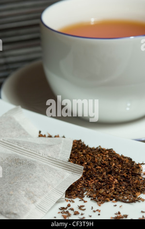 Nahaufnahme von einer Tasse Redbush Tee mit Teebeuteln und lose Teeblätter. Stockfoto