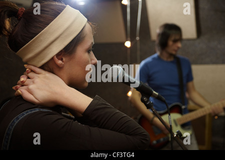 Sänger-Mädchen singt. Elektro-Gitarrist in unscharf Stockfoto