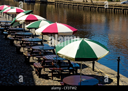 Eine Reihe von Tabellen mit Sonnenschirmen außerhalb des Königs Arms Pub durch den Fluss Ouse. Stockfoto