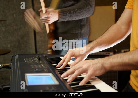 Keyboarder spielen im Studio. Gitarrist in unscharf Stockfoto