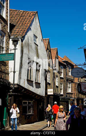 Touristen zu Fuß entlang einem heillosen Durcheinander, Yorks berühmten mittelalterlichen Straße. Stockfoto