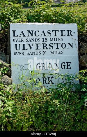 Schwarz und weiß lackiert Schild zeigt die Laufleistung zu Lancaster über Sands sowie Ulverston über Sand und Anfahrt Stockfoto