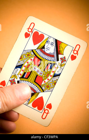 Hand hält eine Queen of Hearts-Spielkarte Stockfoto