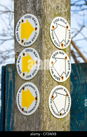 Zeichen, die auf einem hölzernen Pfosten mit Pfeilmarkierungen Richtungen für Centenary Art, Ebor wie und Foss zu Fuß in der Nähe von York. Stockfoto