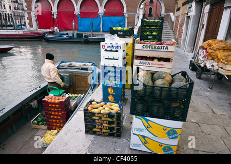 Ein Mann entlädt Obst und Gemüse aus seinem Boot am Markt von Rialto - Venedig, Venezia, Italien, Europa Stockfoto